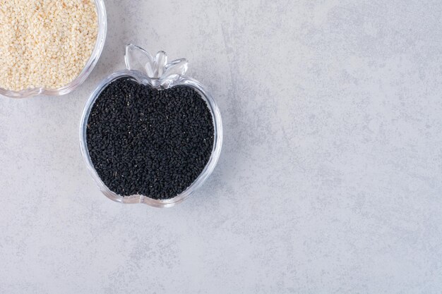 Sesame and black cumin seeds in glass cups. 