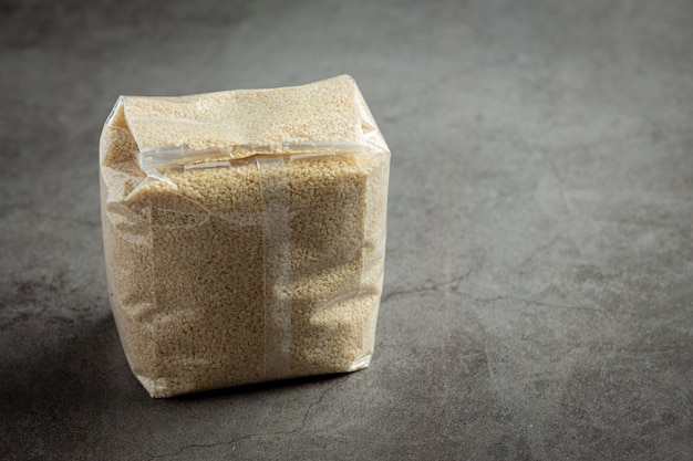 Sesame seeds in bag on dark background