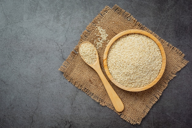 Sesame seeds in bowl on dark background