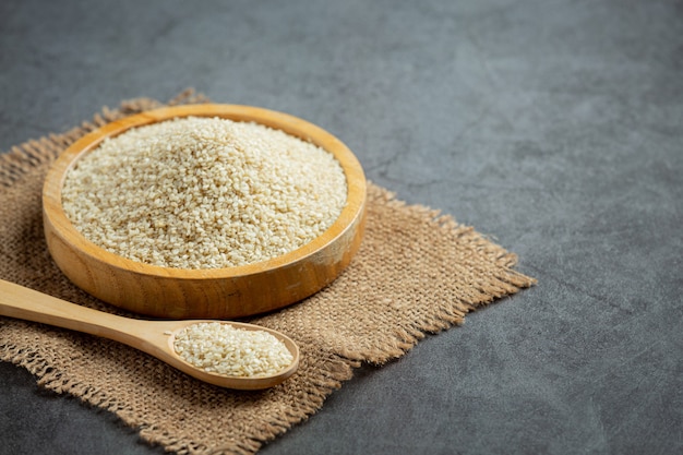 Sesame seeds in bowl on dark background