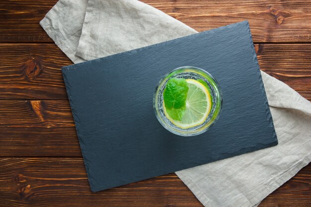 Set of black cardboard and sliced lemon in a bowl on a wooden surface. top view. free space for your text