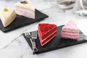 Free photo set of cake portions velvet strawberry cake carrot cake and chocolate cake on marble