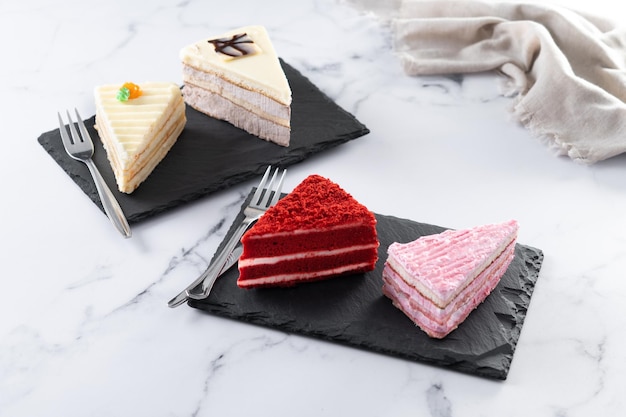 Set of cake portions velvet strawberry cake carrot cake and chocolate cake on marble