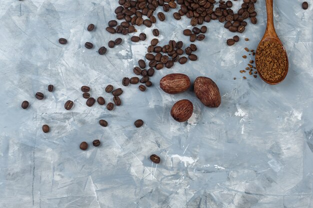 Set of coffee flour in wooden spoon and coffee beans, cookies on a light blue marble background. top view.