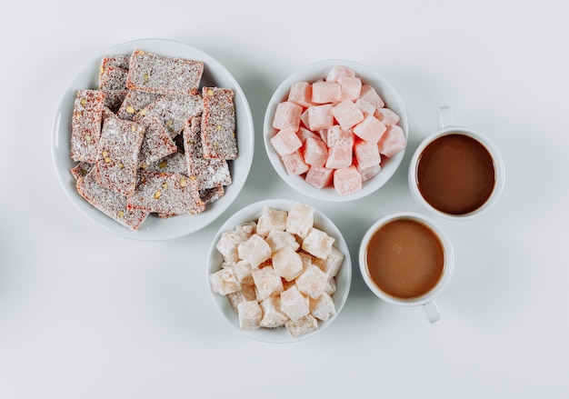 Set of coffee and turkish delight lokums in bowls on a white background. top view.