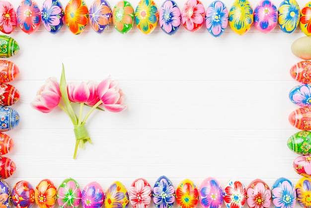 Foto gratuita set di uova colorate su bordi e fiori