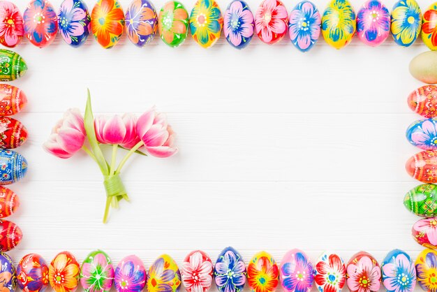 Set of colored eggs on edges and flowers