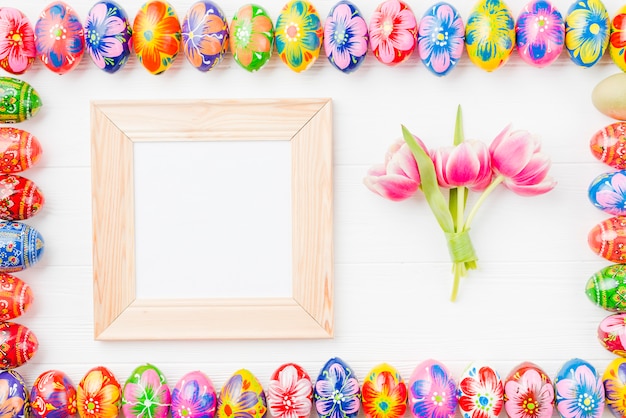 Foto gratuita set di uova colorate su bordi, cornice e fiori