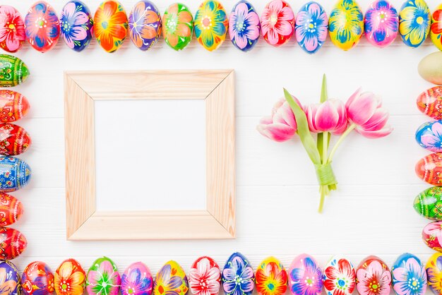 Set of colored eggs on edges, frame and flowers