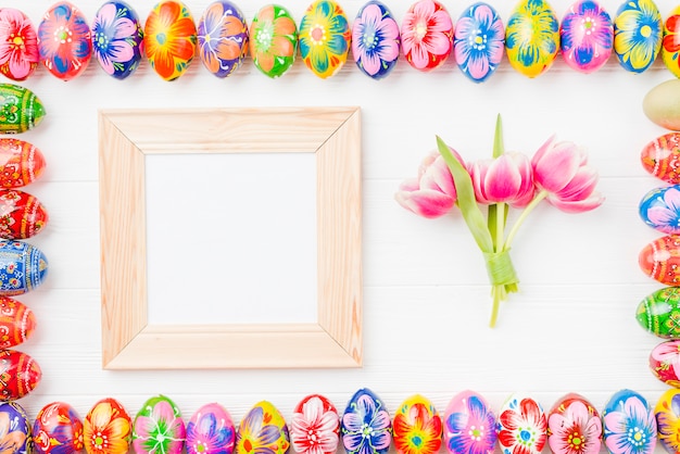 Set of colored eggs on edges, frame and flowers