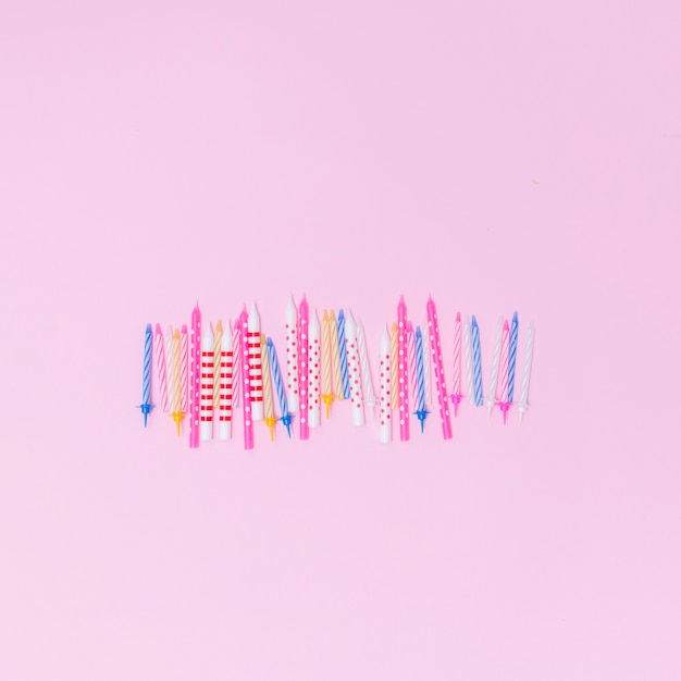 Set of colorful candles on pink background