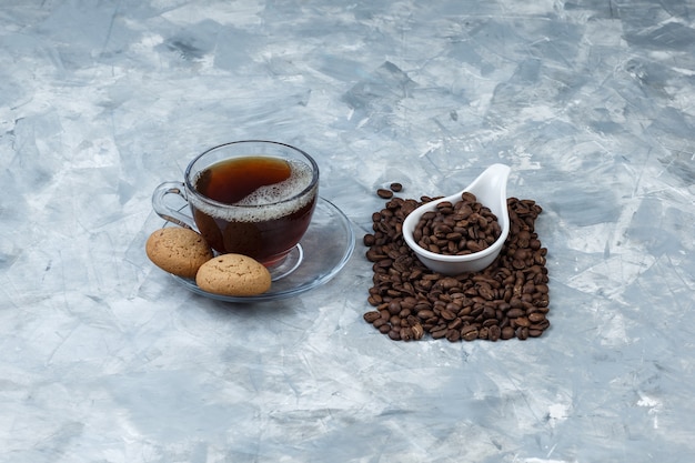 Set di biscotti, tazza di caffè e chicchi di caffè in una brocca di porcellana bianca
