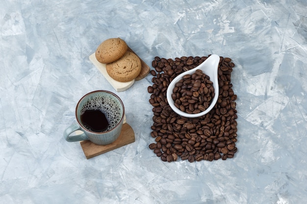 커팅 보드에 쿠키 세트, 흰색 도자기 용기에 커피와 커피 콩 컵