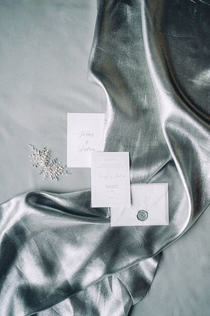 Set of decoration and wedding invitation on a cloth with gray textured background. top view.