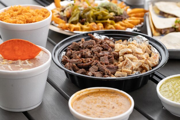 Set of delicious Mexican cuisine food with beef and chicken, salsas, bean dip with chip and rice