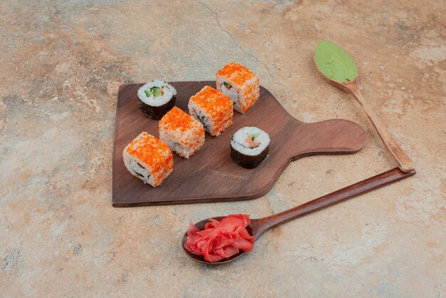 Set of delicious sushi roll with spoon and soy sauce on marble