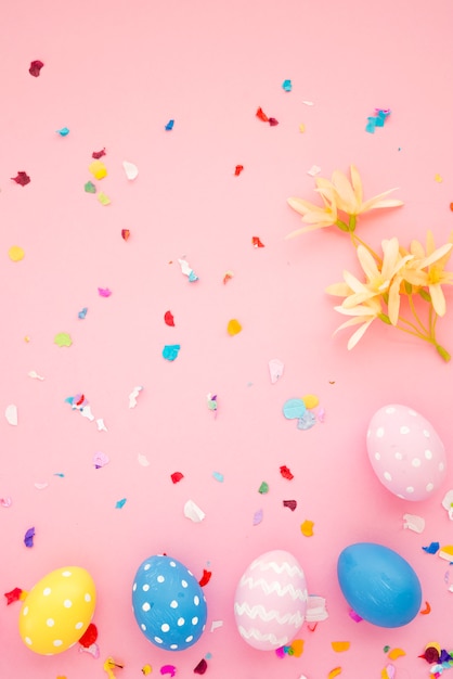 Free photo set of easter eggs between bright confetti