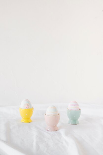 Set of Easter eggs in cups on light textile