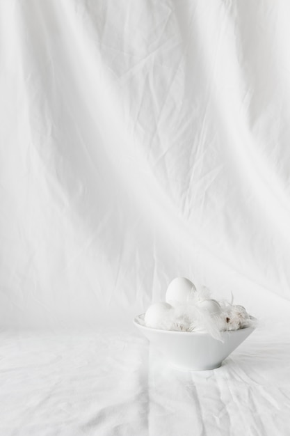 Set of Easter eggs and quills in bowl