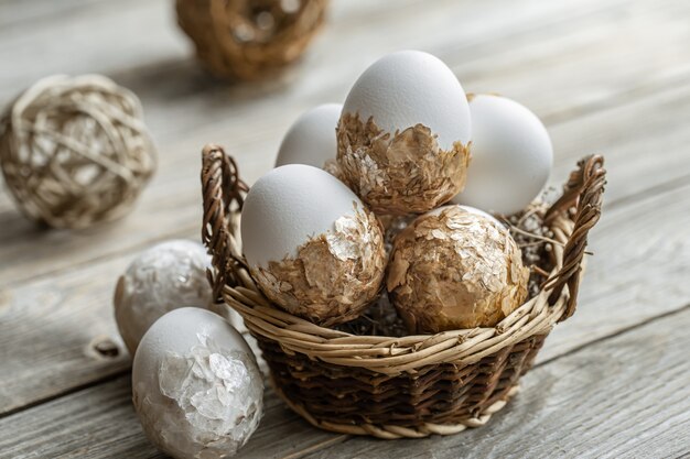 Set of festive Easter eggs in a wicker basket on a blurred background. Easter holiday concept.