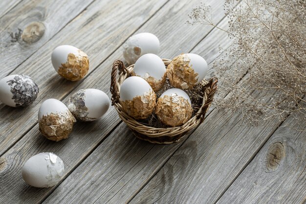 Set of festive Easter eggs in a wicker basket on a blurred background. Easter holiday concept.