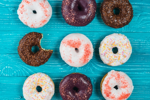 Set of fresh bitten donuts with chocolate glaze and sprinkles