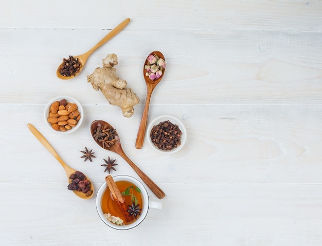 Set of ginger, herbs and spices and herbal tea on a white surface