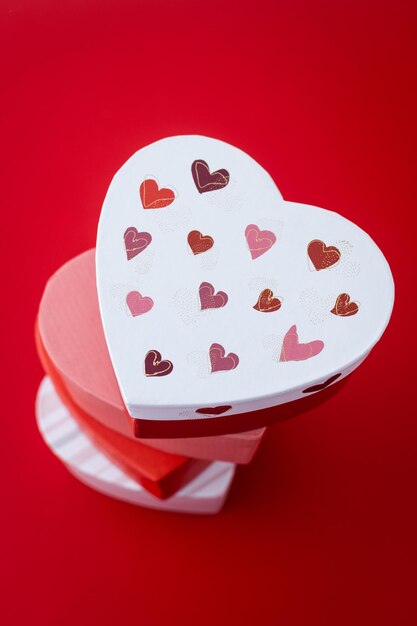 Set heart shaped boxes decorated with pink and red hearts on red backgroundxA