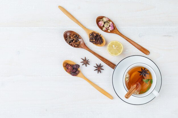 Set of herbs and spices and herbal tea on a white surface