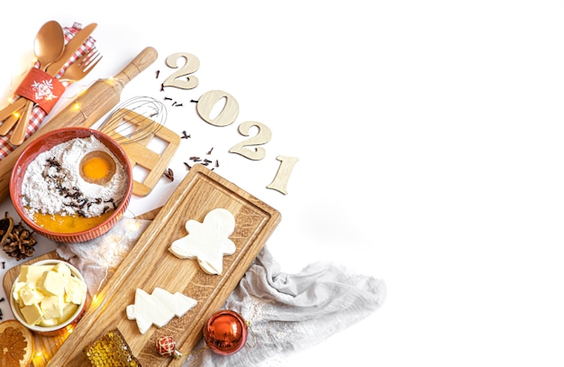 Set of ingredients for making a festive dessert top view on a white background with a wooden number for the coming year.