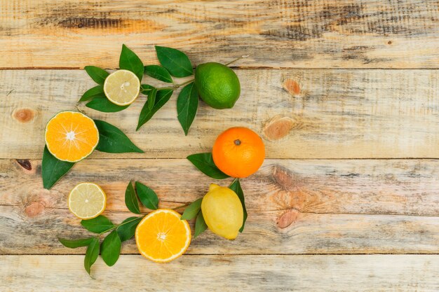 Set of leaves and citrus fruits on a wooden board