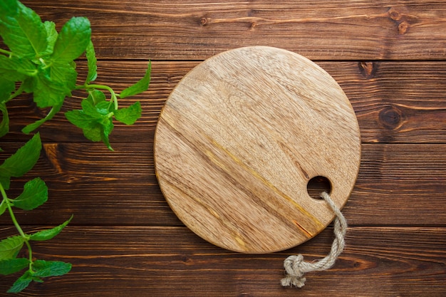 Free photo set of leaves and cutting board on a wooden background. top view. copy space for text