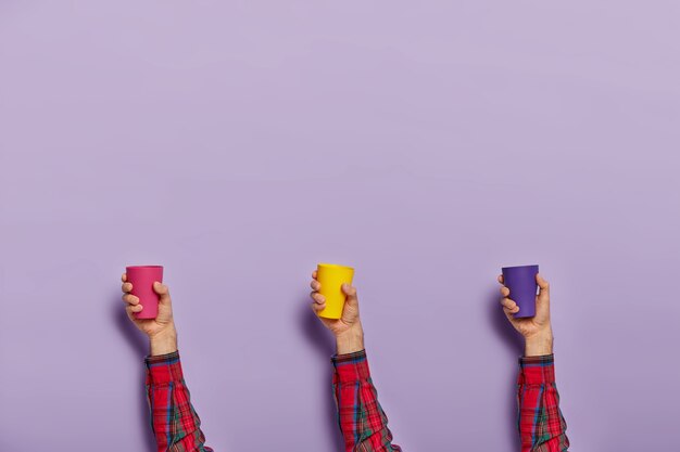 Set of male hands with colorful empty plastic cups