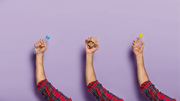 Set of man hands with crushed recyclable plastic bottles