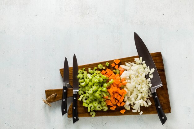木製​の​まな板​と​刻んだ​野菜​の​ナイフ​の​セット