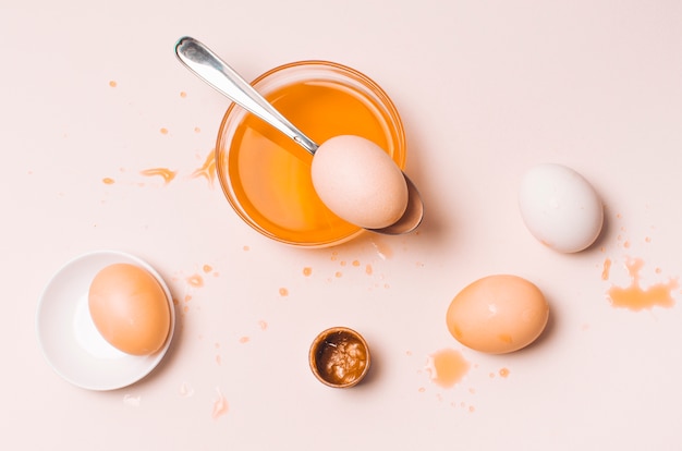 Set of orange Easter eggs between blots, spoon and dye liquid