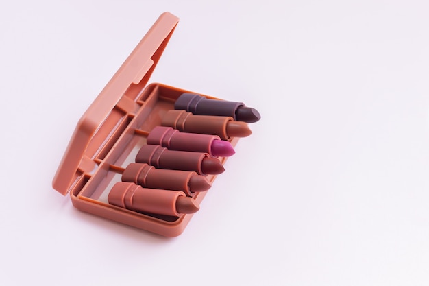 Set or palette of lipsticks on light pink background. luxury cosmetic product concept