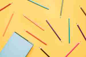 Free photo set of pencils scattered on yellow background