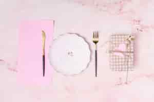 Free photo set of present box near plate, paper and cutlery