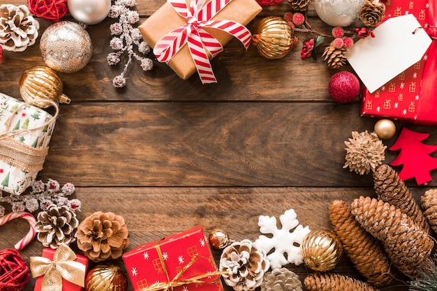 Set of present boxes in Christmas wraps near ornament balls