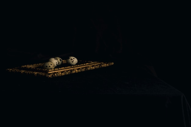 Set of quail eggs on photo frame between blackness