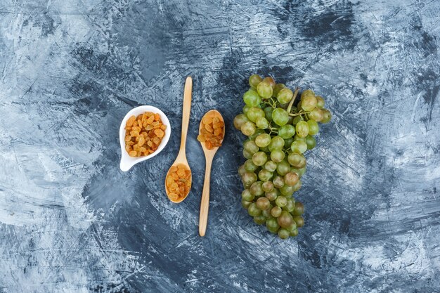 Set of raisins and green grapes on a grungy plaster background. top view.