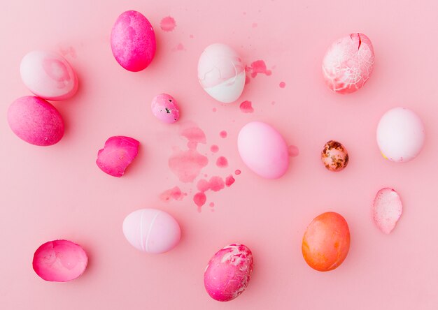 Set of rose and white Easter eggs between splashes of dye liquid