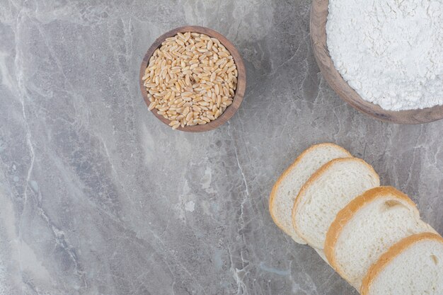 Set of slices toast bread with oat grains on marble surface