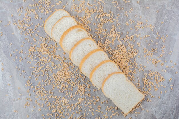 Set of slices toast bread with oat grains on marble surface