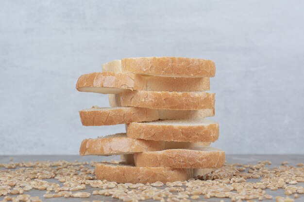 Set of slices toast bread with oat grains on marble surface