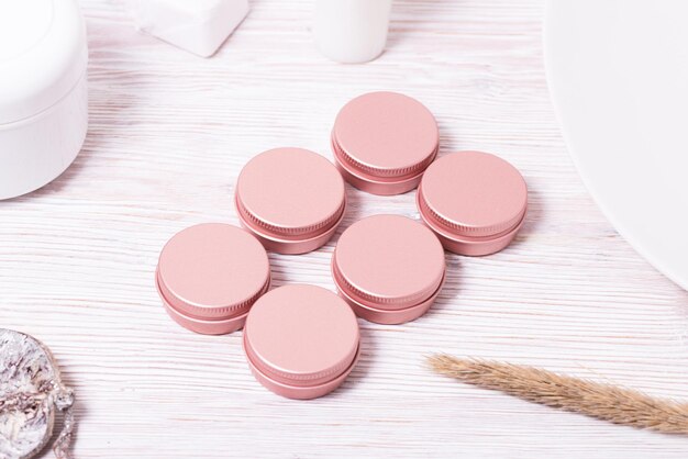 Set of small tin metal cases for cosmetic on wooden table
