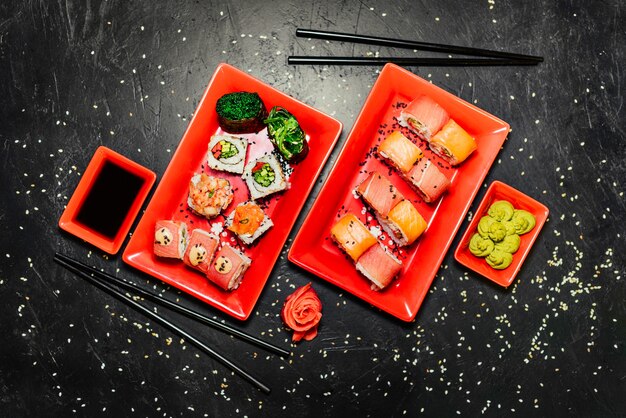 Set of sushi, Japanese knife, chopsticks and on dark stone table. 