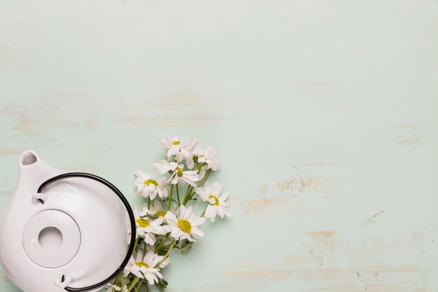 Set of teapot and camomile bouquet 