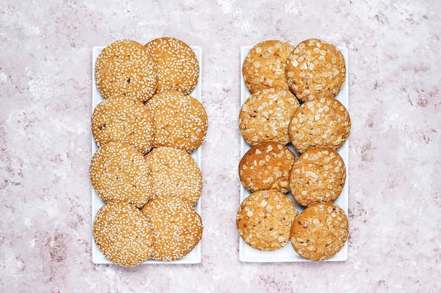 Set of various american style cookies on a light concrete background. Shortbread with confetti, sesame seed, peanut butter, oatmeal and chocolate chip cookies.